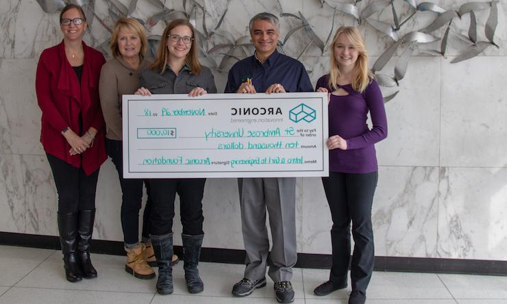 Engineering student and professor accept a check from the Arconic Foundation 